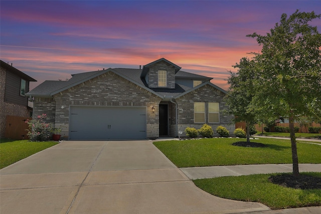 view of front of house featuring a garage and a yard