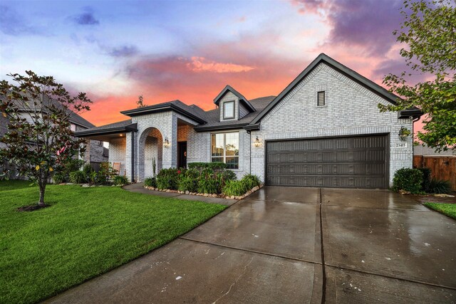 view of front of property with a garage and a lawn