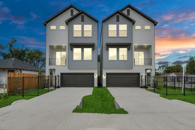 view of front of property with a balcony, a yard, and a garage