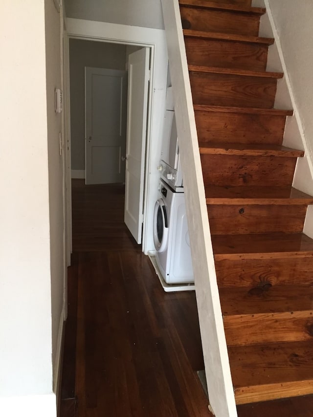 staircase featuring hardwood / wood-style floors and stacked washing maching and dryer