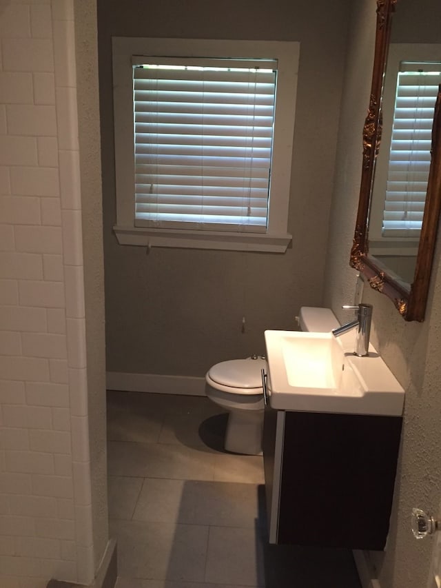 bathroom with toilet, vanity, and tile patterned floors