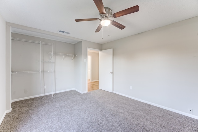 unfurnished bedroom featuring ceiling fan, a closet, and carpet