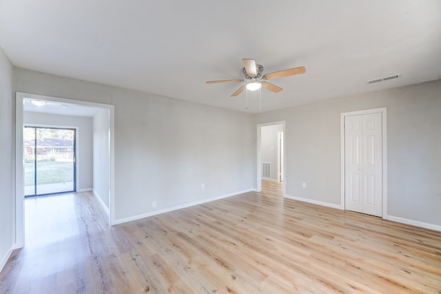 empty room with ceiling fan and light hardwood / wood-style flooring