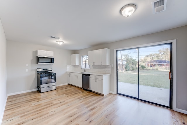 kitchen featuring white cabinets, sink, light hardwood / wood-style floors, and stainless steel appliances