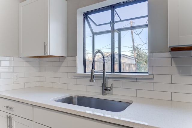 kitchen featuring white cabinetry, plenty of natural light, and light stone countertops