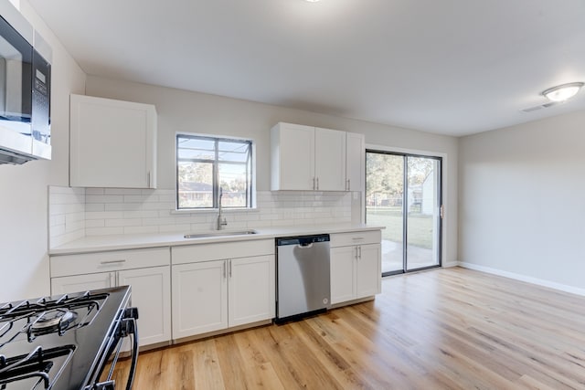 kitchen with white cabinets, sink, a healthy amount of sunlight, and stainless steel appliances