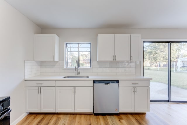 kitchen with white cabinetry, light wood-type flooring, stainless steel dishwasher, and sink