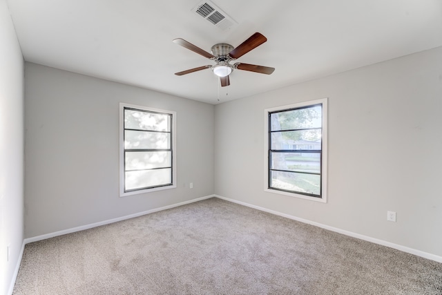 carpeted empty room featuring a healthy amount of sunlight and ceiling fan