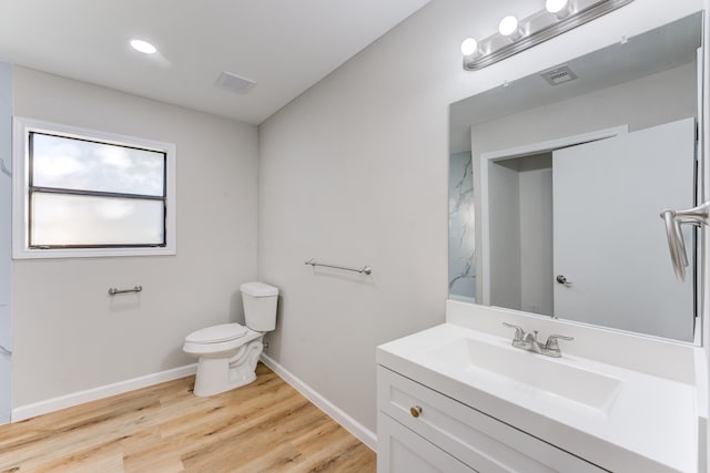 bathroom featuring toilet, vanity, and hardwood / wood-style floors