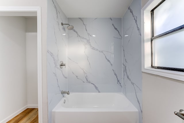 bathroom with plenty of natural light, tiled shower / bath, and hardwood / wood-style flooring