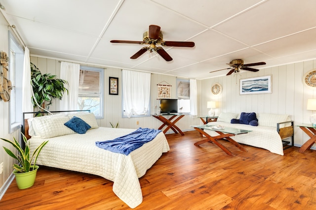 bedroom featuring ceiling fan, multiple windows, and wood-type flooring