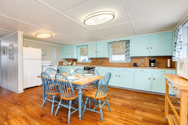 dining area featuring a drop ceiling and light wood-style floors