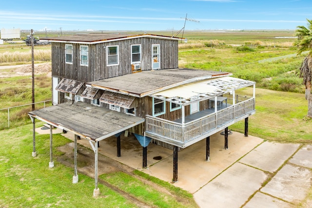 rear view of house featuring a lawn and a wooden deck