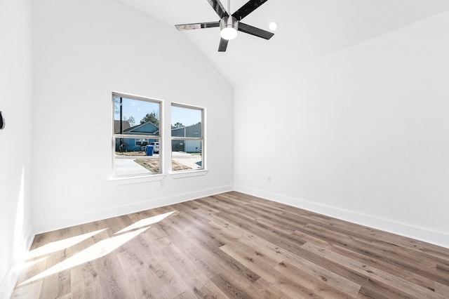 empty room featuring high vaulted ceiling, ceiling fan, and light hardwood / wood-style flooring