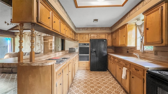 kitchen featuring black appliances, sink, and tasteful backsplash