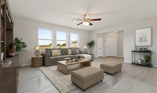 living room with ceiling fan and light hardwood / wood-style flooring