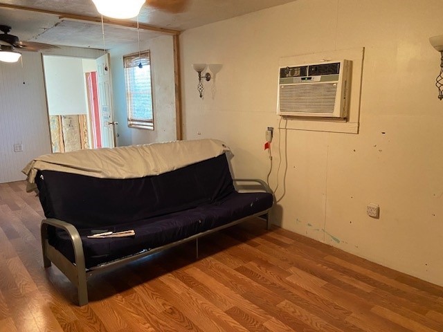 381 Center St, Matagorda, TX 77457 - living room featuring wood finished floors, an AC wall unit, and ceiling fan