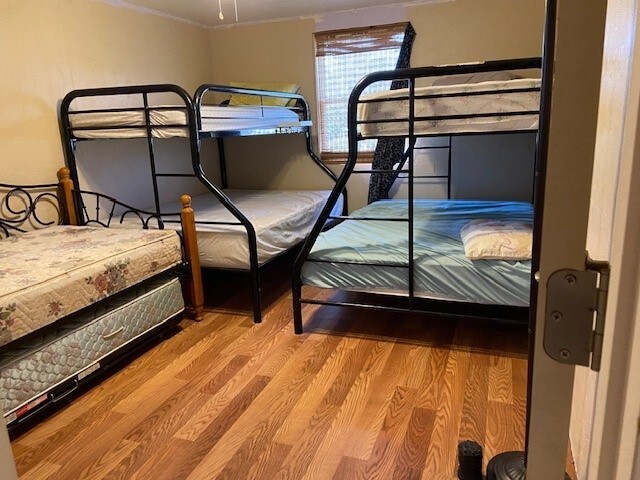 381 Center St, Matagorda, TX 77457 - unfurnished bedroom featuring wood finished floors and crown molding