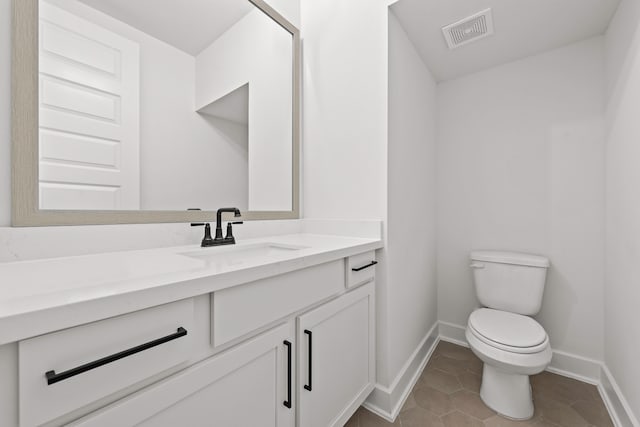 bathroom featuring tile patterned flooring, vanity, and toilet