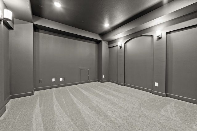 carpeted cinema room featuring a textured ceiling