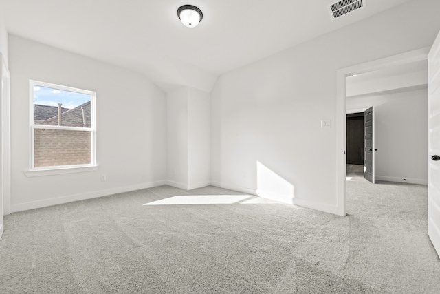 empty room with lofted ceiling and light colored carpet