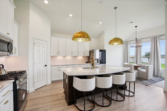 kitchen featuring light hardwood / wood-style flooring, an island with sink, stainless steel appliances, and sink