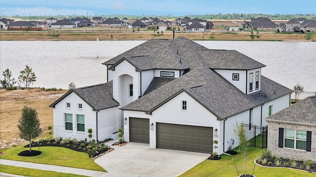 view of front of house with a water view, a garage, and a front yard