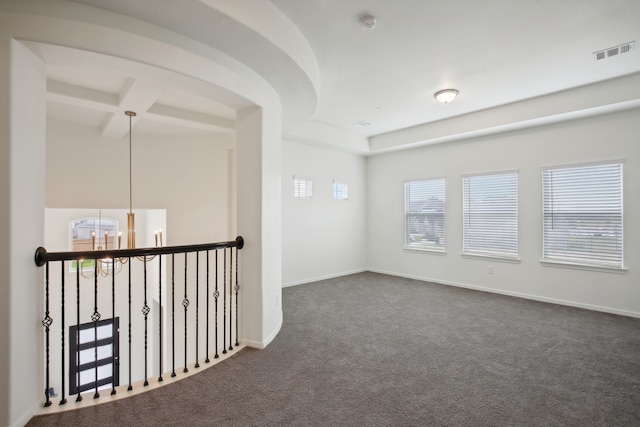 carpeted spare room with beam ceiling and a chandelier