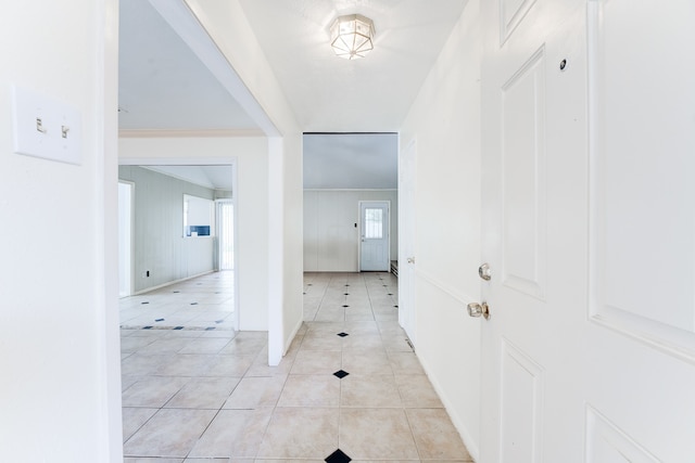 corridor featuring light tile patterned floors and ornamental molding