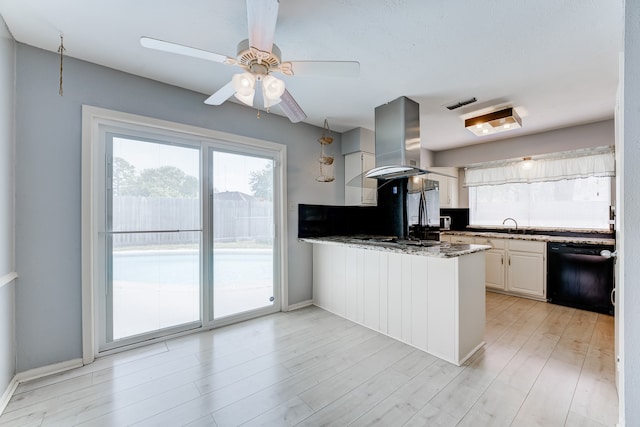 kitchen featuring island exhaust hood, white cabinetry, black dishwasher, light hardwood / wood-style floors, and kitchen peninsula