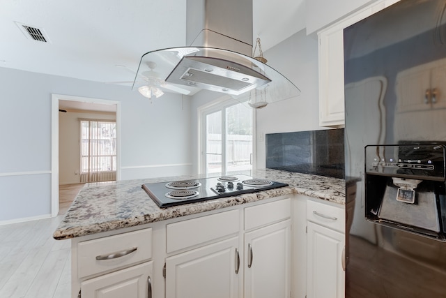 kitchen featuring white cabinetry, refrigerator with ice dispenser, island range hood, and light hardwood / wood-style flooring