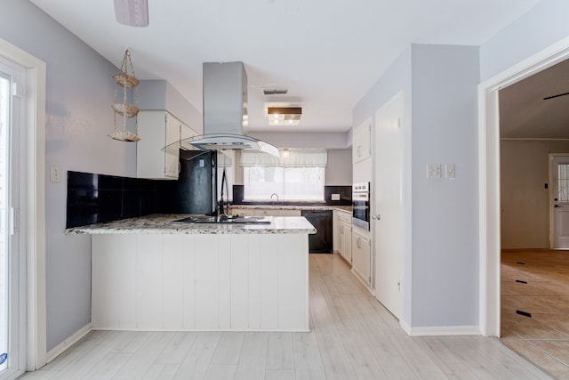 kitchen featuring island range hood, stainless steel oven, kitchen peninsula, and white cabinets