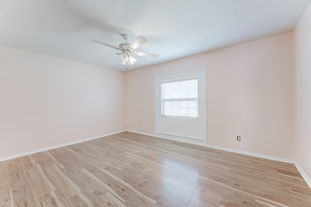 empty room with ceiling fan and light hardwood / wood-style flooring