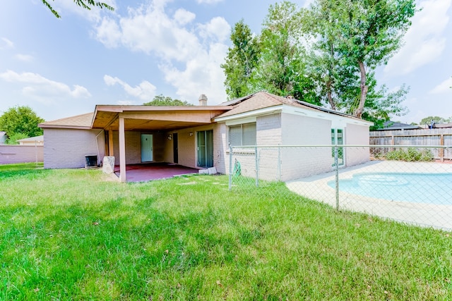 rear view of property with a lawn and a patio area