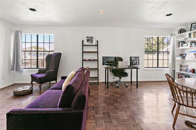 office space with dark parquet floors, a textured ceiling, and plenty of natural light