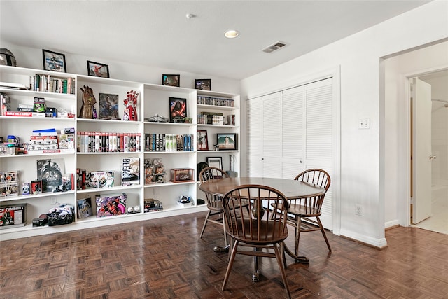 dining space with dark parquet flooring