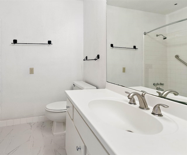 bathroom with vanity, toilet, and a tile shower