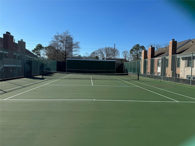 view of tennis court with basketball hoop