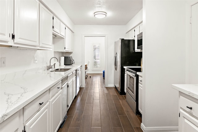 kitchen featuring light stone counters, stainless steel appliances, white cabinetry, dark hardwood / wood-style flooring, and sink