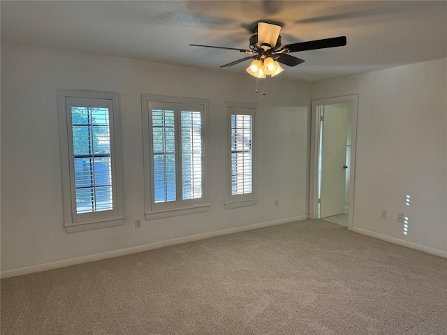 empty room with carpet flooring, a healthy amount of sunlight, and ceiling fan