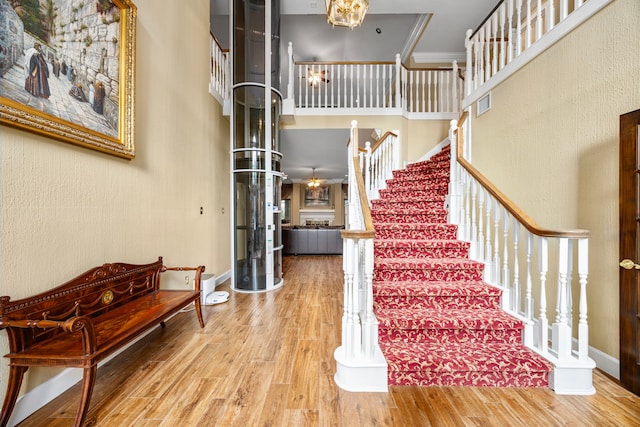 foyer with a high ceiling, hardwood / wood-style flooring, and crown molding