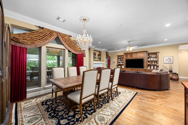 dining space featuring ceiling fan with notable chandelier, light wood-type flooring, and crown molding