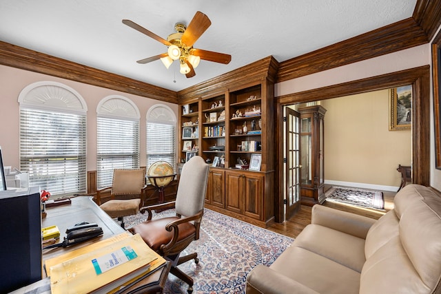 office area featuring ceiling fan, wood-type flooring, crown molding, and a textured ceiling