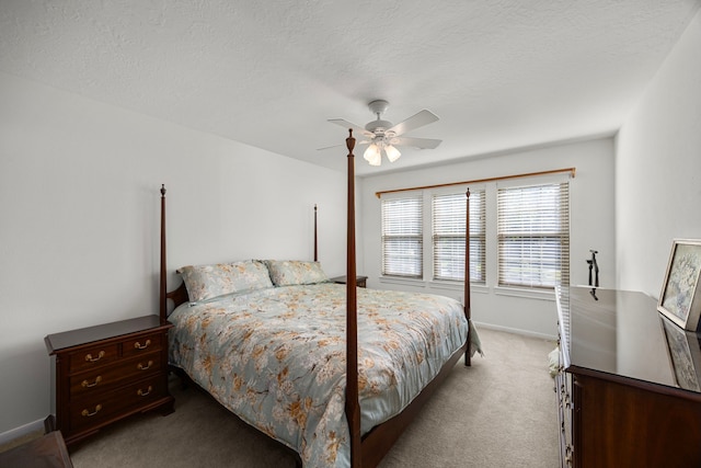 carpeted bedroom with ceiling fan and a textured ceiling