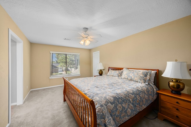 carpeted bedroom featuring ceiling fan and a textured ceiling