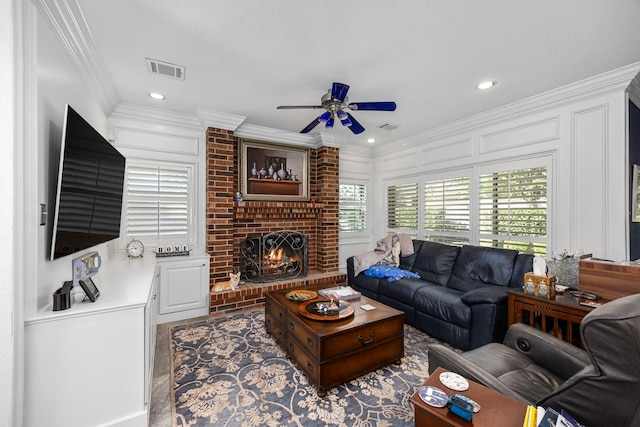 living room with a fireplace, ceiling fan, and ornamental molding