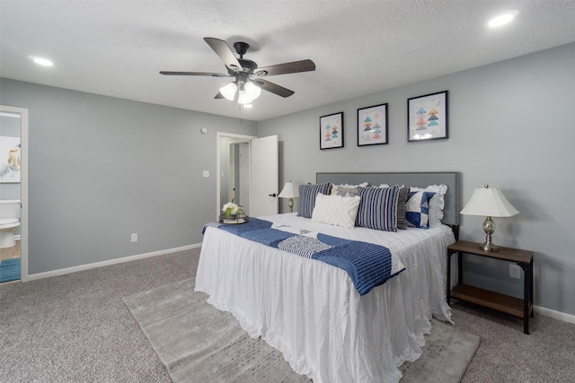 carpeted bedroom featuring ensuite bath, ceiling fan, and a textured ceiling