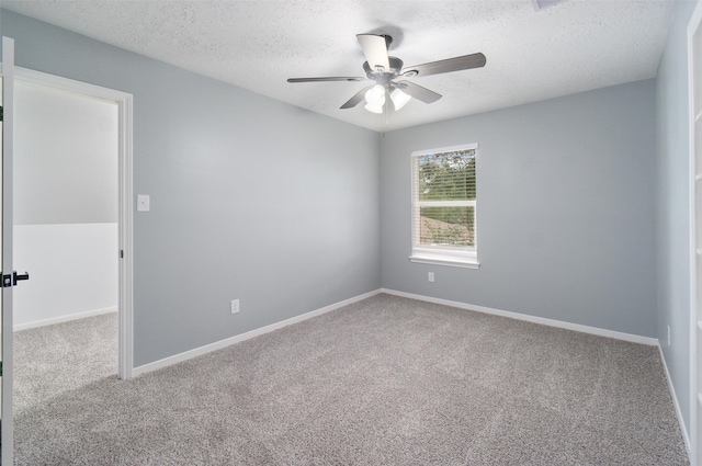 carpeted spare room with a textured ceiling and ceiling fan