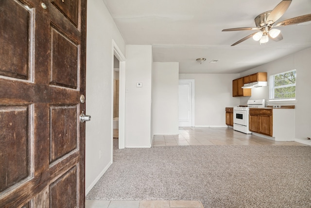 kitchen with light colored carpet, white range oven, and ceiling fan