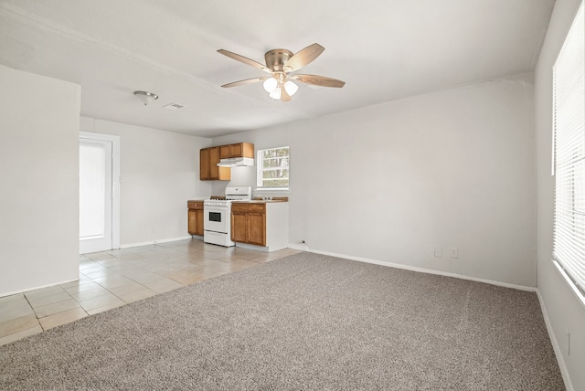 interior space featuring ceiling fan, light colored carpet, and white range oven